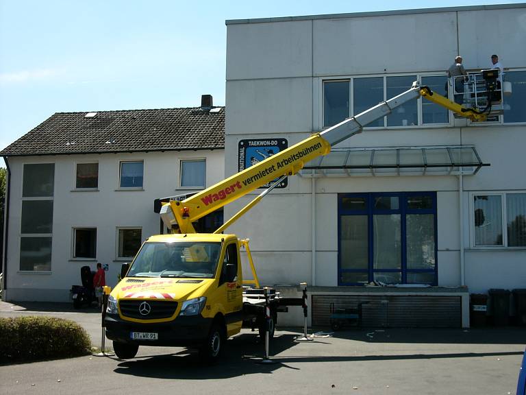 Fassadenarbeiten an einem alten Industriegebäude mithilfe einer kleinen LKW-Arbeitsbühne.