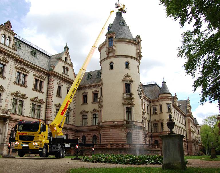 Wartungsarbeiten am Spitzdachturm eines alen Schlosses mithilfe einer Wagert LKW-Arbeitsbühne.