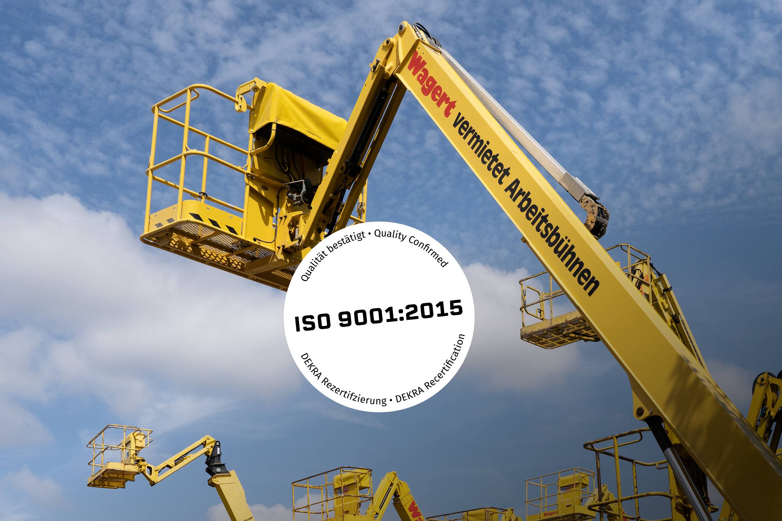 Mehrere gelbe Arbeitsbühnen vor blauem Himmel mit eingeblendetem Qualitätssiegel „ISO 9001:2015 – DEKRA Rezertifizierung“